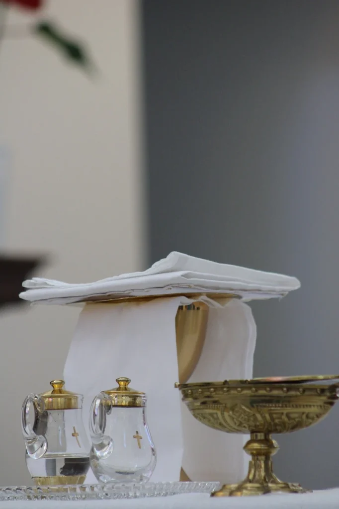 Catholic altar prepared for Mass with golden chalice, cruets of water and wine, and white linens.”