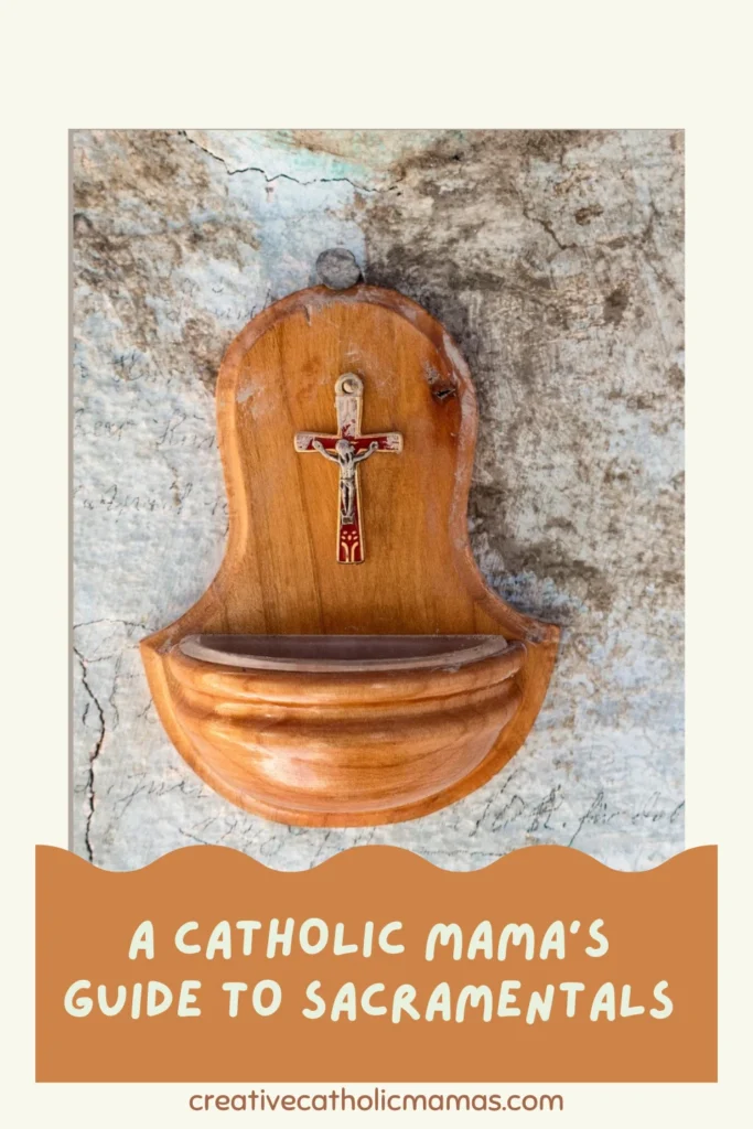 Wooden holy water font with a small crucifix on a textured wall, with the text “A Catholic Mama’s Guide to Sacramentals.”
