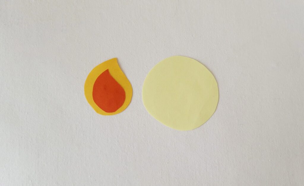 Paper flame pieces cut out in red and yellow along with a circular glow shape.
